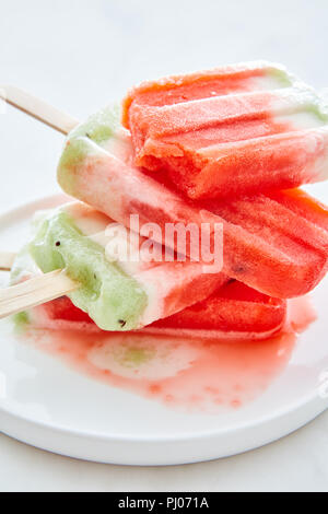 Nahaufnahme eines Stapels von Schmelzen hausgemachte berry Eis in einer Schüssel mit verschütteten Flüssigkeiten auf grauem Marmor tisch. Gesund Sommer Dessert Stockfoto