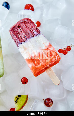 Eis am Stiel mit frischen Beeren und Früchte auf Eiswürfel. Kalten Sommer Nachtisch. Flach Stockfoto