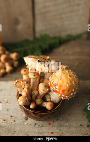 Rustikale Tisch und Tasse mit mysrerious Champignons Dessert. Holz, Märchen & geheimnisvolle Geschöpf Konzept, Magie, fantastisches Essen Stockfoto