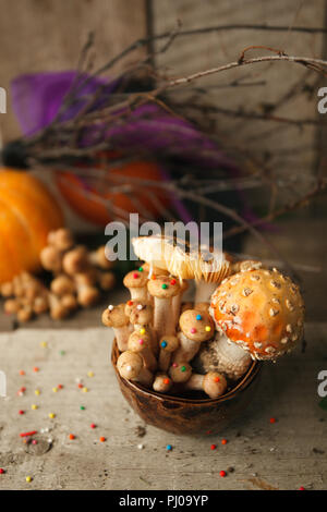 Holz, Märchen & mysteriösen Wesen, das Konzept - poisonus Pilze in den Kelch mit Süßwaren Dekor auf Holztisch, Magie, fantastisches Essen Stockfoto