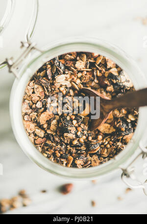 Buchweizen und Müsli mit Haselnüsse in Glas Glas mit Löffel Stockfoto