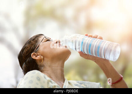 Indische Frau Trinkwasser aus der Flasche Stockfoto
