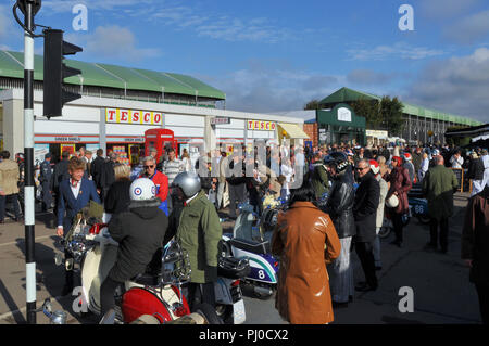 Street Scene am Goodwood Revival mit Menschen im Zeitraum Kleidung und Mopeds. Retro Tesco. Kostümen. Zeitlose Stockfoto