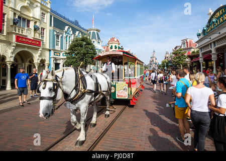 Von Pferden gezogene Straßenbahn entlang der Hauptstraße unterwegs in Disneyland Paris. Stockfoto