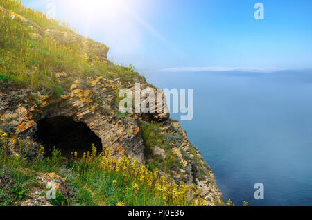 Höhle in einem Felsen am Meer. Über dem Wasser sehen sie den Nebel. Stockfoto