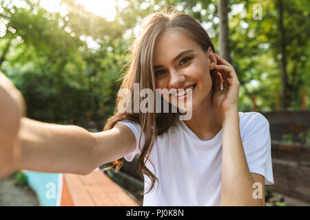 Fröhliche junge Mädchen eine selfie mit Handy im Park im Freien Stockfoto