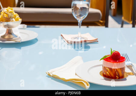 Erdbeerkuchen und ein Glas Wasser. Stockfoto