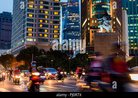 Ho Chi Minh City: der Verkehr in der Straße neben Bitexco Financial Tower, Renaissance Riverside Hotel Saigon & Melinh Point Tower mit Tran Hung Dao Statue Stockfoto