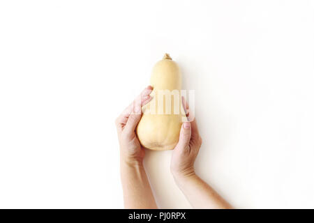 Kürbis Kürbis in weibliche Hände auf weißem Hintergrund. Herbst Stoffzusammensetzung gestaltet. Herbst, Thanksgiving Design. Halloween Anordnung. Flach, Ansicht von oben. Stockfoto