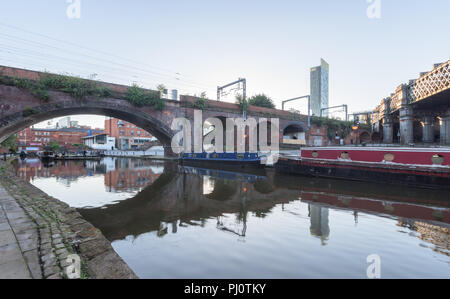 Blick von der Leinpfad neben der Bridgewater Canal auf das Castlefield Viadukt Brücke und das Hilton Hotel in Manchester. Stockfoto