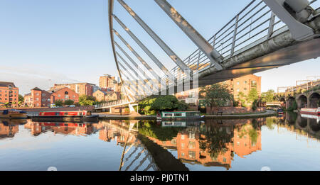 Die Unter Kaufmann Brücke auf der Bridgewater Canal in Castelfield, Manchester, zeigt ein angelegtes Boot und Wohnungen Stockfoto