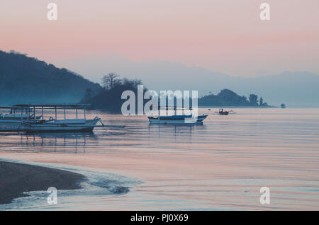 Traditionelle indonesische Holz Fischerboot / Katamaran während Serene Sonnenaufgang; Lombok, Indonesien Stockfoto