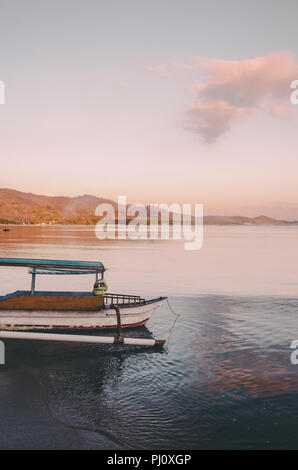 Traditionelle indonesische Holz Fischerboot / Katamaran während Serene Sonnenaufgang; Lombok, Indonesien Stockfoto