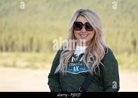 Erwachsene Frau mit langen blonden Haaren - Porträt im Denali Nationalpark. Mädchen trägt ein Sweatshirt Hoodie Stockfoto