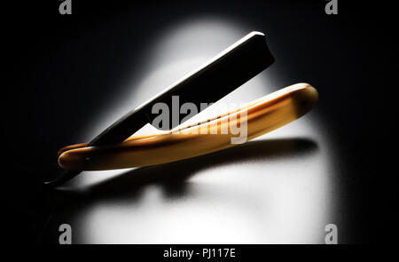 Rasiermesser in Silhouette auf schwarzem Hintergrund. Vintage Rasur Pflege für Männer. Friseur Rasiermesser. Stockfoto