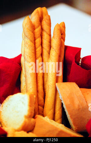 Crunchy italienisches Brot klebt zusammen mit Baguette in Scheiben geschnitten Brot Korb auf Tisch im Restaurant in Udine, Italien Stockfoto