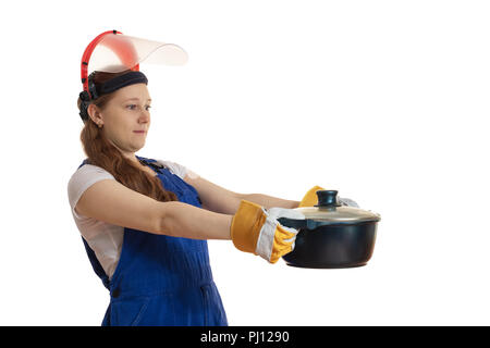 Das Mädchen in der Arbeitskleidung und eine schützende Maske hält eine Pfanne in der Hand, lassen Sie sich überraschen. Stockfoto