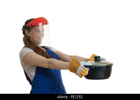 Das Mädchen in der Arbeitskleidung und eine schützende Maske hält eine Pfanne in der Hand, lassen Sie sich überraschen. Stockfoto