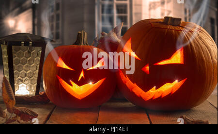 Spooky Halloween Kürbisse auf Holzplanken in der Nacht. Stockfoto