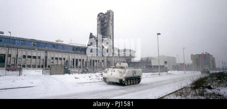 5. März 1993 während der Belagerung von Sarajevo: ein dänischer YPR-765 AIFV/APC Festplatten vorbei an den Ruinen der Oslobodenje Gebäude, das ein starkes Symbol während der Belagerung gebildet. Stockfoto