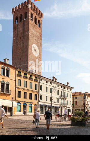 Mittelalterlichen Stadtturm, Piazza Garibaldi, Bassano del Grappa, Vicenza, Italien im frühen Morgenlicht mit Einheimischen zu Fuß durch das Quadrat Stockfoto