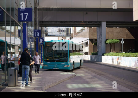 Frankfurt, Deutschland - 11. August 2018: Reisende am Busbahnhof des Flughafens Frankfurt am Main mit einem geparkten Bus am 11. August 2018 in Frankfurt am Main. Stockfoto