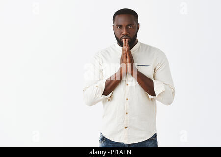 Studio shot von schweren, stark und männlich Afrikanische amerikanische Sportler Verbeugung vor Meister der Kampfkunst im asiatischen Stil mit Palmen im Beten, Ernst starrte auf Kamera, namaste Geste Stockfoto