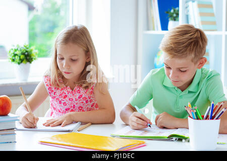 Cute Schulkinder sind kam zurück in die Schule und Lernen in der Tabelle im Klassenzimmer Stockfoto