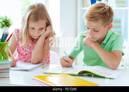 Cute Schulkinder sind kam zurück in die Schule und Lernen in der Tabelle im Klassenzimmer Stockfoto