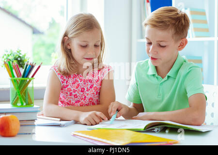 Cute Schulkinder sind kam zurück in die Schule und Lernen in der Tabelle im Klassenzimmer Stockfoto