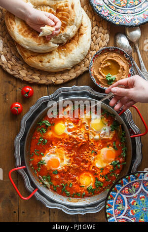 Familie Frühstück mit Shakshuka, Hummus und Brot. top View Stockfoto