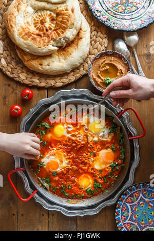 Familie Frühstück mit Shakshuka, Hummus und Brot. top View Stockfoto