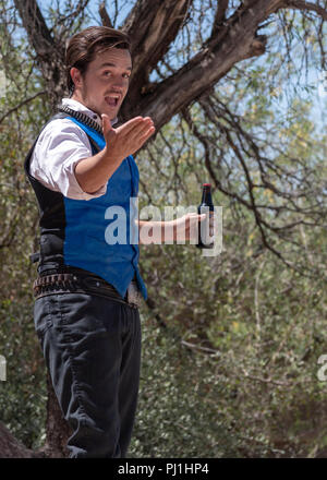 Schauspieler gekleidet in Old West style Kleidung beschreibt die Vorteile der Flasche Elixier in seinem hatte. Stockfoto