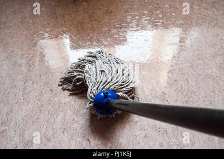 Point-of-View shot abwischen Boden durch Seil mop mit Reflexion des Fensters in den nassen Boden Stockfoto