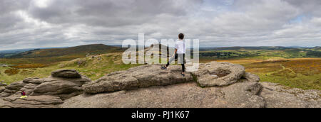 Mädchen genießt die Aussicht auf Haytor in Dartmoor, Großbritannien Stockfoto