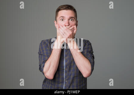 Europäischen mann Herunterfahren seinen Mund auf dunklem Hintergrund Stockfoto