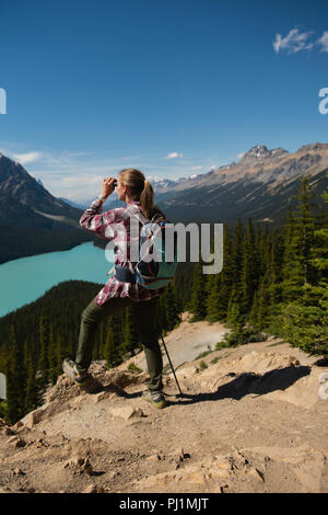 Weibliche Wanderer durch ein Fernglas in der Landschaft suchen Stockfoto