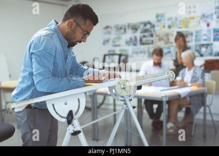 Männliche Mitarbeiter über Ausarbeitung Tabelle Stockfoto