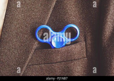Blue Spinner in der Tasche der Blazer business Geschäftsmann. Antistress Spielzeug für nervös. Leistungsstarke Spinner, Twister für Hände Unterhaltung drehen Stockfoto