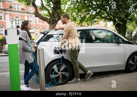 Paar interagieren während des Ladevorgangs Elektroauto Stockfoto