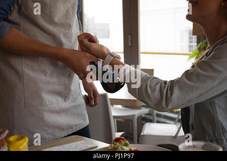 Frau Zahlung mit der NFC-Technologie auf smartwatch im Cafe Stockfoto