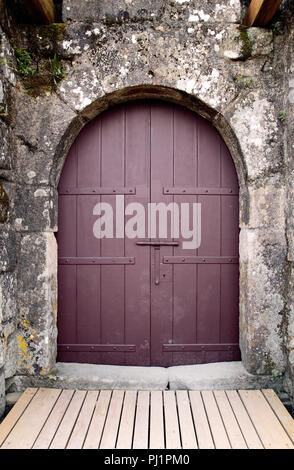 Alte braune Schloss Tür sehen, verwitterten Granit arch Stockfoto