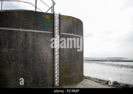 Wasserstand marker Messen tide Ebenen am Meer Wand bei Severn Strand, Bristol, UK. Ebbe. Tag Licht. Stockfoto