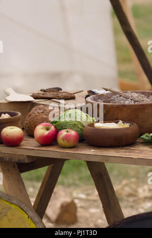 Mittelalterliche speisen Vorbereitung mit Brot, Butter, Käse, Obst in hölzernen Schüsseln oder trenchers Stockfoto