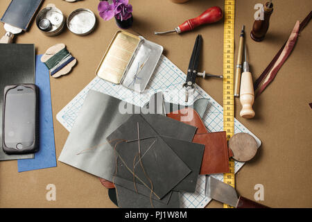 Set aus Leder Handwerk Werkzeuge auf dem Papier Hintergrund. Arbeitsplatz für Schuhmacher. Stockfoto