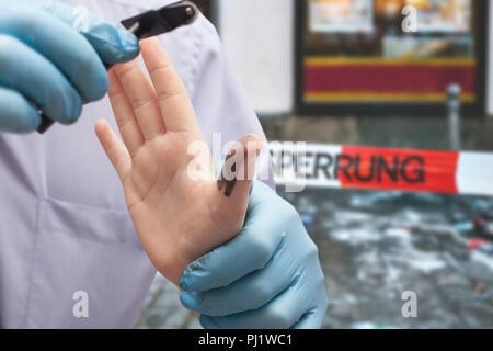 Der Polizist nimmt Fingerabdrücke von den Verdächtigen. Untersuchung der Kriminalität. Stockfoto