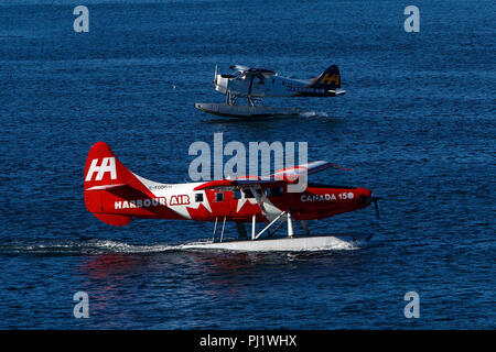 De Havilland Canada DHC-3 T Vazar Turbine Otter (C-FODH) von Harbour Air mit dem Canada 150 Livery Taxis betrieben Vergangenheit De Havilland Canada DHC-2 Mk.1 Biber (C-Gfdi) durch West Coast Air, den Hafen von Vancouver, Vancouver, British Columbia, Kanada betrieben Stockfoto