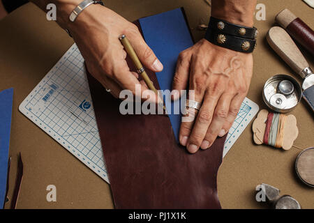 Der Prozess der Herstellung von handgefertigten Lederetui in das Leder Werkstatt. Stockfoto