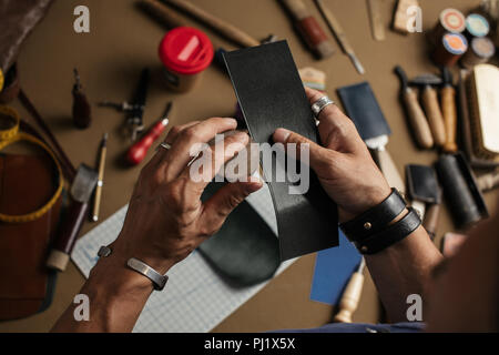 Der Prozess der Herstellung von handgefertigten Lederetui in das Leder Werkstatt. Stockfoto