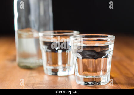 Wodka im Glas. Transparente Alkohol auf Holztisch. Stockfoto